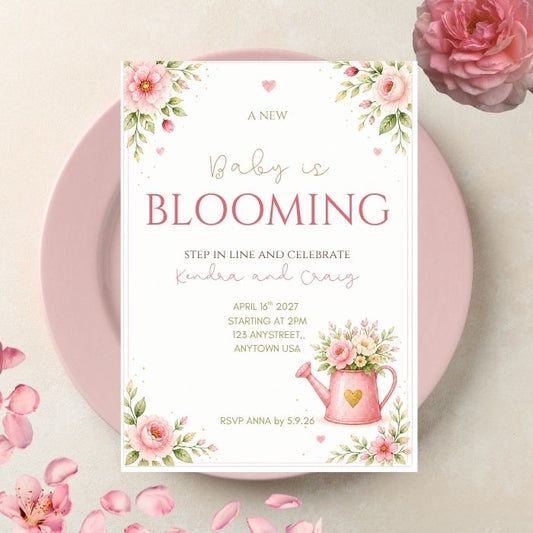 a baby in bloom themed baby shower invitation 5x7" with pink and green florals displayed on a pink plate