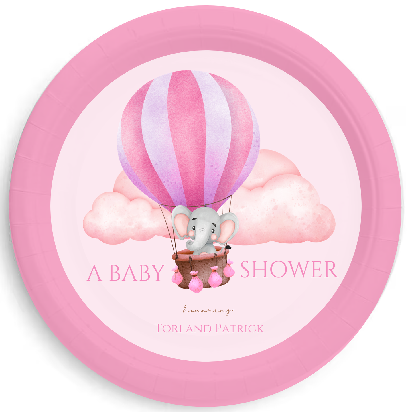 a 9" pink party plate features an elephant floating away over pink clouds in a hot air balloon